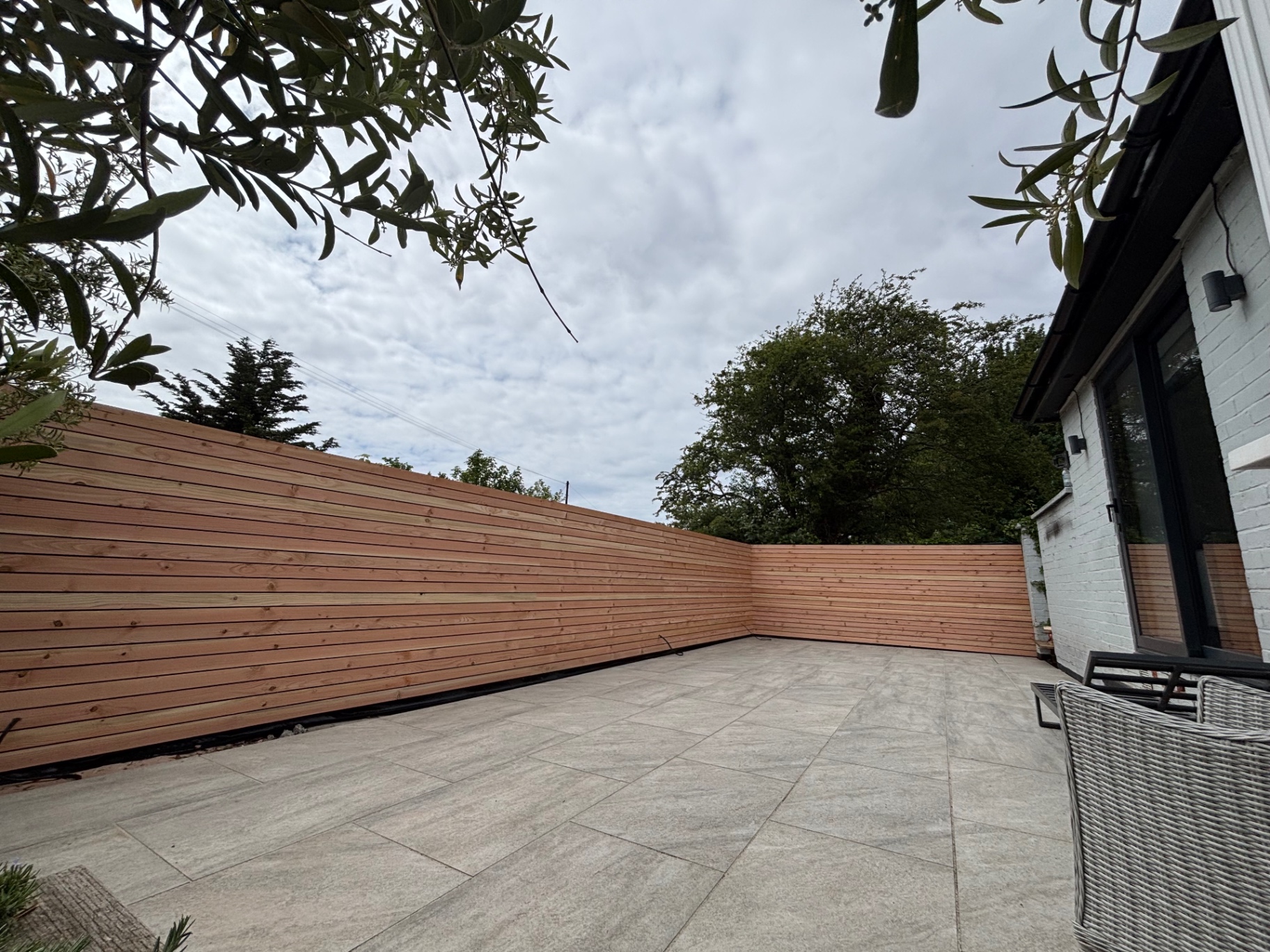 Grey porcelain patio with cedar slat fencing