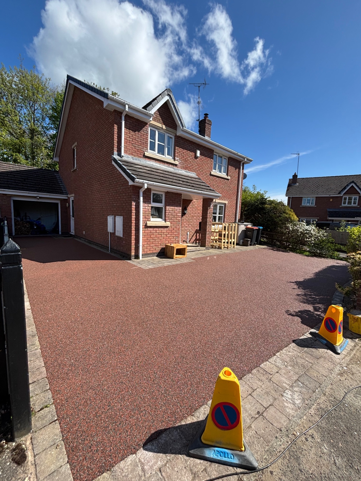 Red resin bound driveway in front of brick home
